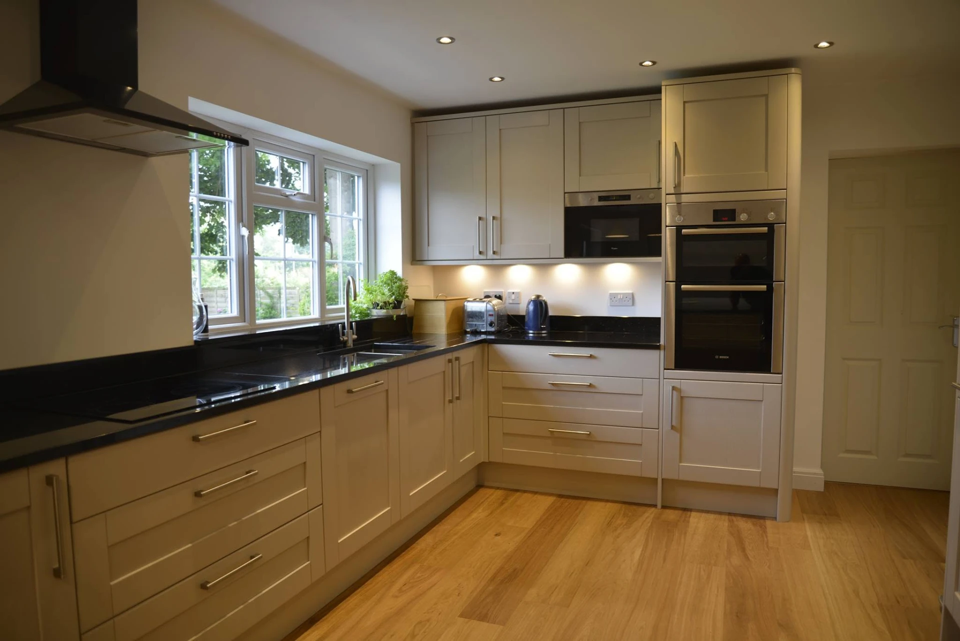 Open-plan shaker kitchen with granite breakfast bar, built by RGS Joinery and Building
